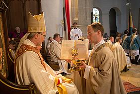 Bischof Gregor Maria Hanke überreicht Ulrich Schmidt Brot und Wein. pde-Foto: Anita Hirschbeck