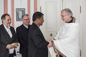 Father Louis brachte Bischof Gregor Maria Hanke (rechts) bei seinem Besuch ein indisches Gewand als Gastgeschenk mit. Im Hintergrund (von links) Weltkirchereferent Gerhard Rott und Domkapitular Prälat Dr. Christoph Kühn, Beauftragter für die Angelegenh