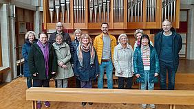 Gruppe von Menschen vor einer Orgel