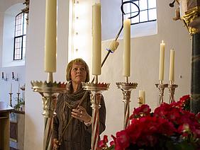 Gerda Bauernfeind hat als Mesnerin viele Aufgaben – vor dem Gottesdienst zündet sie zum Beispiel die Kerzen am Hochaltar an. pde-Foto: Anika Taiber