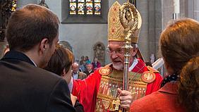 Der Bischof von Eichstätt mit Kindern denen er die Firmung spendet