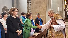 Bischof Hanke und Ex-Ministerin Müller beim Friedengruß. pde-Foto: Geraldo Hoffmann
