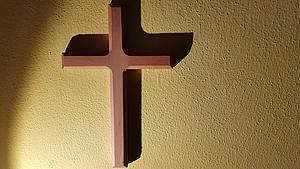 Ein Kreuz hängt an der Wand