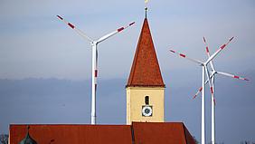 Kirche mit Windrädern im Hintergrund