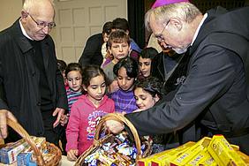 Die Kinder in der Erstaufnahmeeinrichtung freuten sich über die mitgebrachten Süßigkeiten von Generalvikar Isidor Vollnhals (links) und Bischof Gregor Maria Hanke (rechts). pde-Foto: Michael Heberling