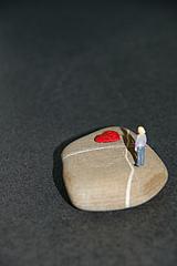 Miniaturmännchen auf Stein mit Herz
