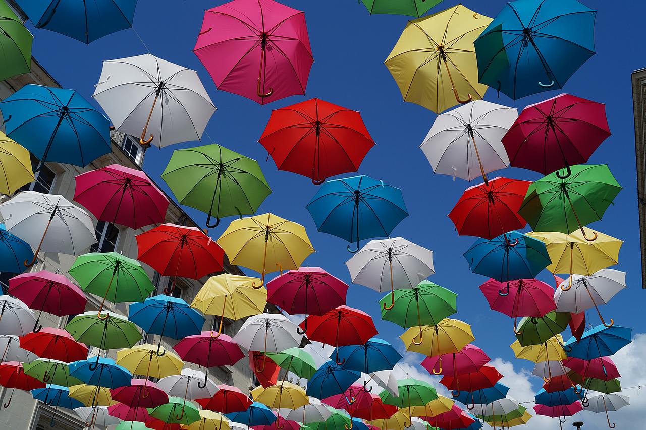 Bunte Regenschirme die zum Himmel aufsteigen.