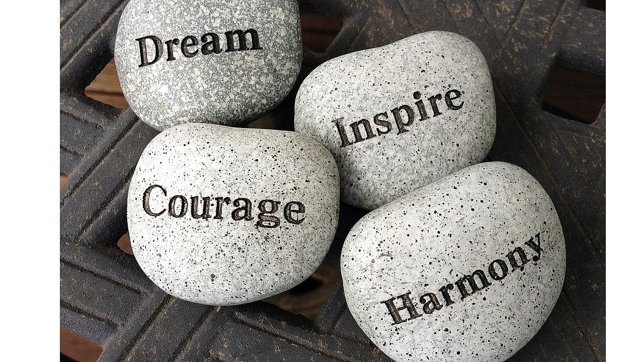 vier Steine mit Aufschriften: Dream, Inspire, Courage, Harmony