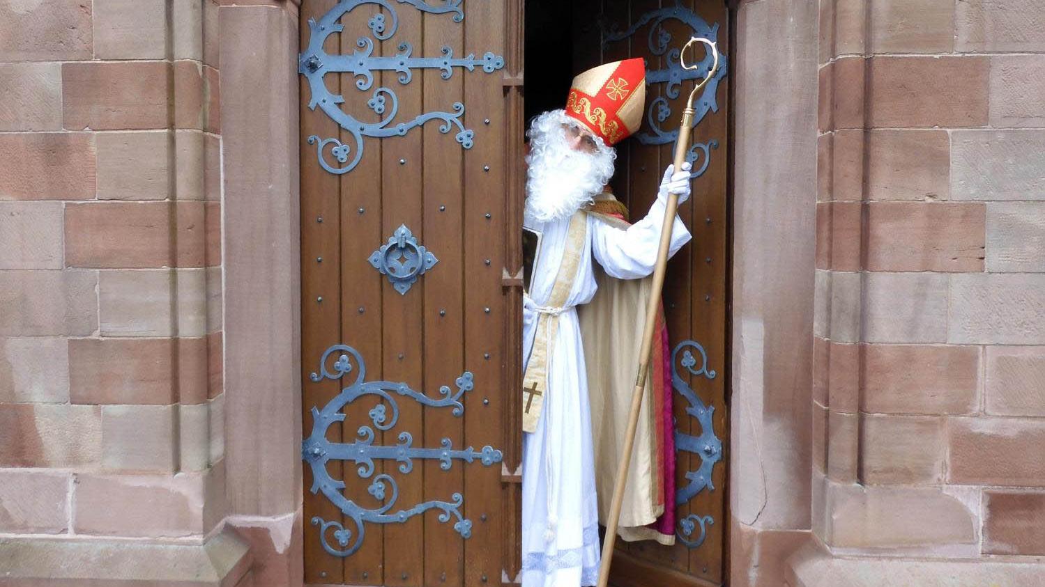 Nikolaus schaut aus einer Tür.