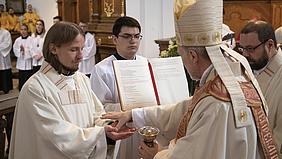 Bischof Gregor Maria Hanke salbt Patrick Zachmeier bei der Priesterweihe die Hände.
