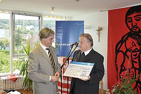Christian Kipper (links), überreichte Caritasdirektor Brummer einen symbolischen Scheck