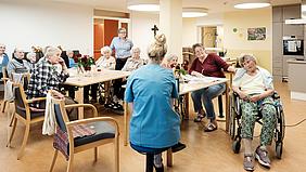 Mitarbeiterin im Gespräch mit Bewohnerinnen und Bewohnern des Caritas-Seniorenheims Dietfurt.