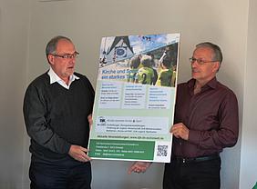 Geistlicher Beirat Pfarrer Richard Herrmann (links) und Präsident Nikolaus Schmidt stellen das Plakat "Kirche und Sport - ein starkes Team!" vor. (Foto: Hans Kirschner, DJK)