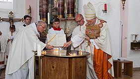 Bischof Gregor Maria Hanke und Pfarradministrator Pater Gregor Gockeln entzünden Weihrauch an fünf Stellen auf dem Altar.