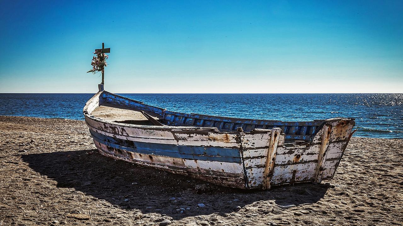altes Boot mit Kreuz am Meer
