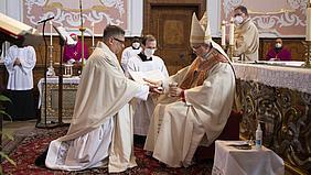 Bischof Gregor Maria Hanke salbt die Hände von Michael Krämer mit Öl.