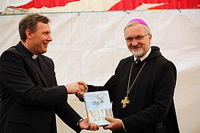 Regens Wölfle überreicht Bischof Hanke das neue Buch zum Seminarjubiläum
