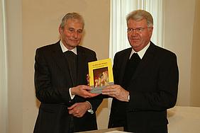 Domdekan Klaus Schimmöller (links) überreicht Generalvikar Dompropst Johann Limbacher (rechts) die Festgabe des Domkapitels Eichstätt.