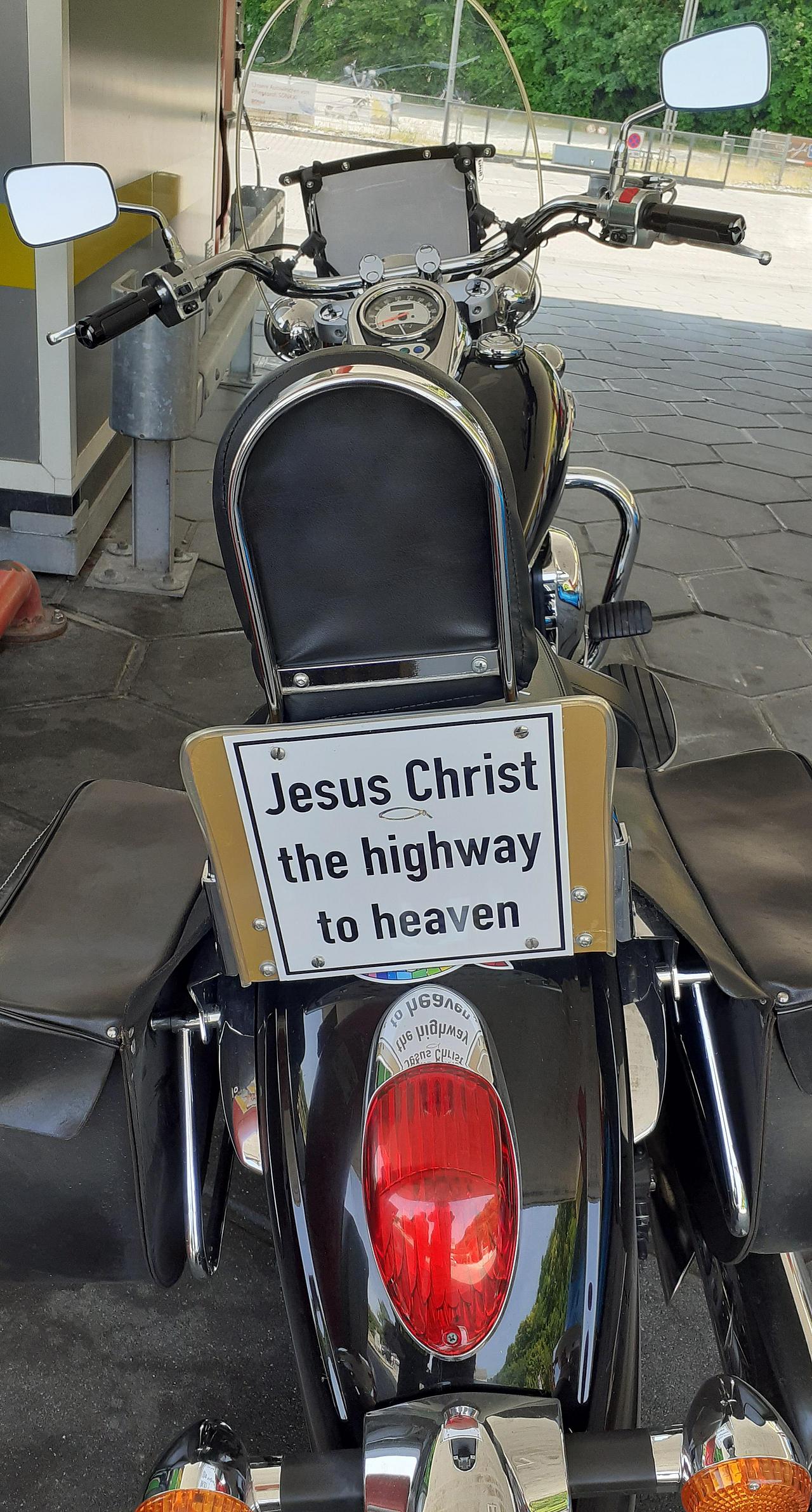 Motorrad mit Schild mit der Aufschrift Jesus Christus, die Autobahn in den Himmel.