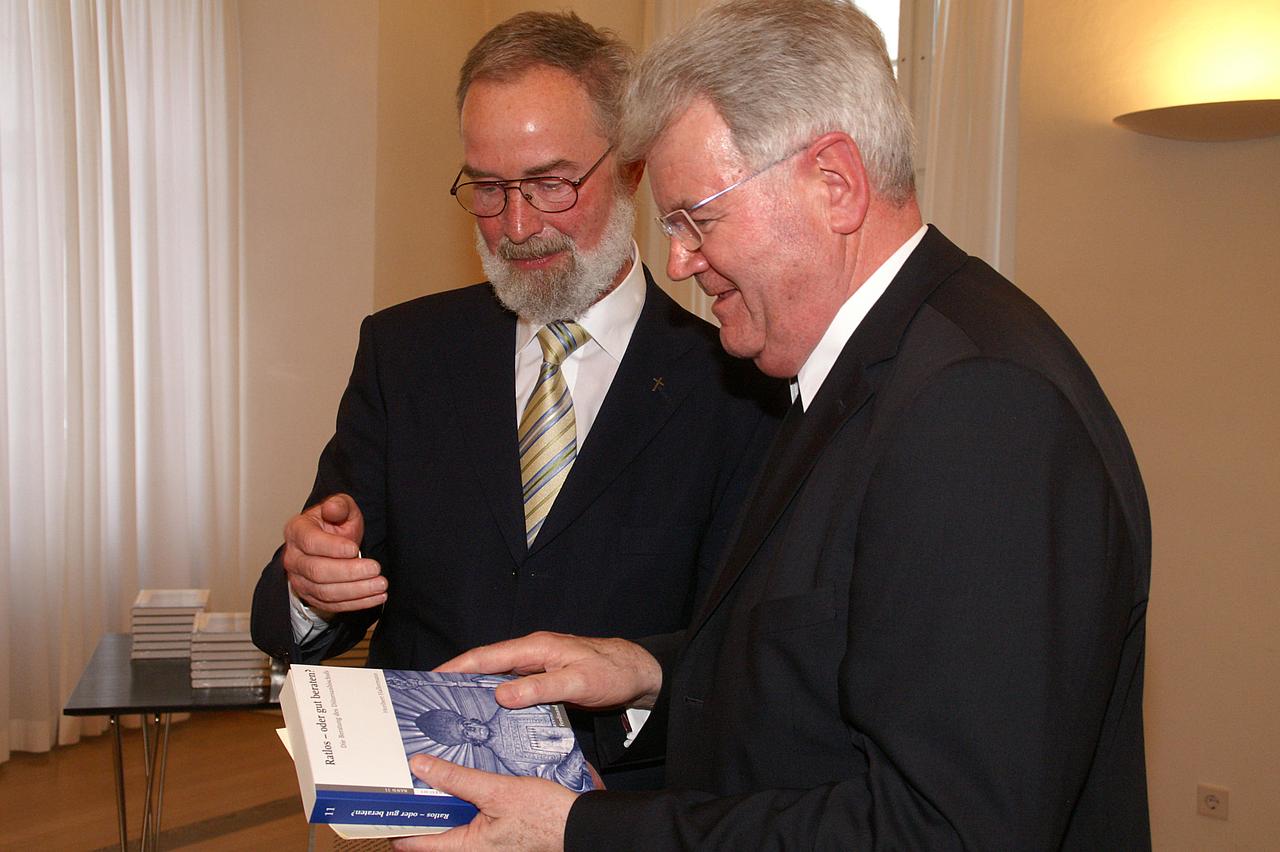 Professor Dr. Heribert Hallermann (links) überreicht sein neuestes Buch an den Eichstätter Generalvikar Johann Limbacher (rechts).
