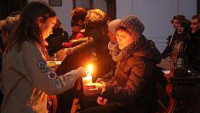 Die Pfadfinder geben das Licht bei der Aussendungsfeier an die Gläubigen weiter. pde-Foto: Johannes Heim